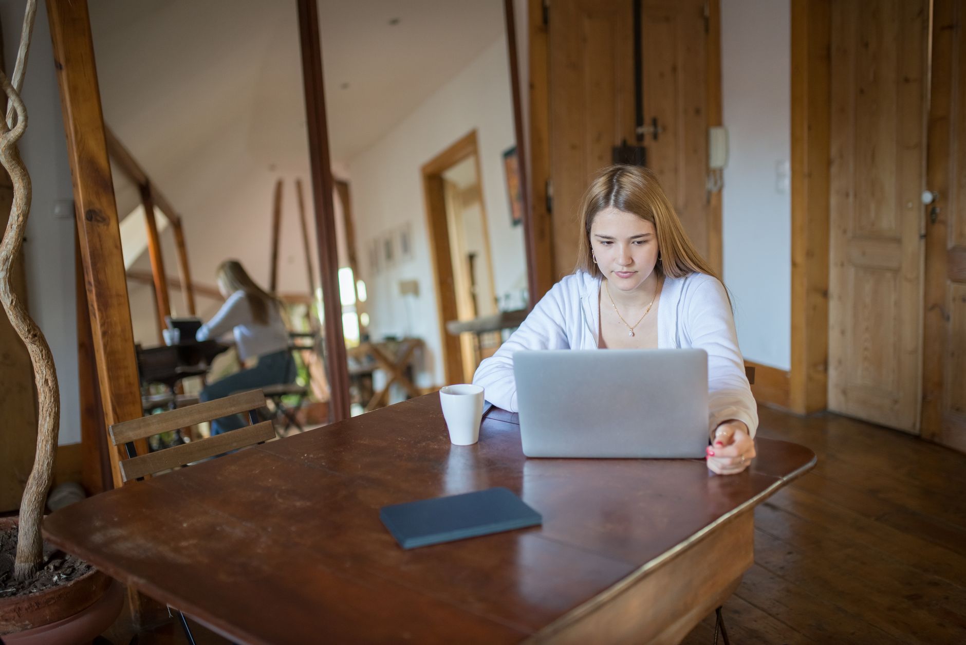 Mulher trabalhando em um notebook em uma mesa de madeira